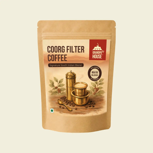 A stand-up kraft paper pouch of Coorg Filter Coffee by Grandpa House, featuring a vintage-style illustration of coffee brewing equipment and beans on the front label, set against a solid cream background.