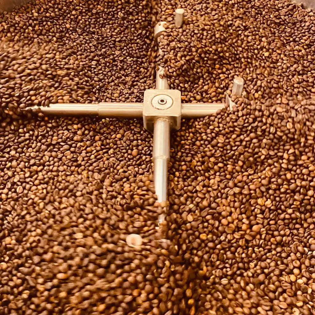 Fresh coffee beans being roasted in small batches for Grandpa House Coffee.